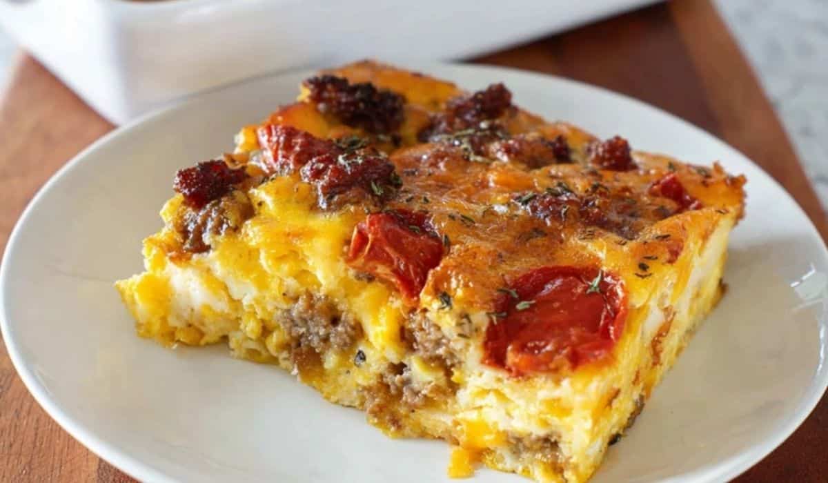 Chorizo and Egg Breakfast Casserole slice with melted cheese and tomato topping