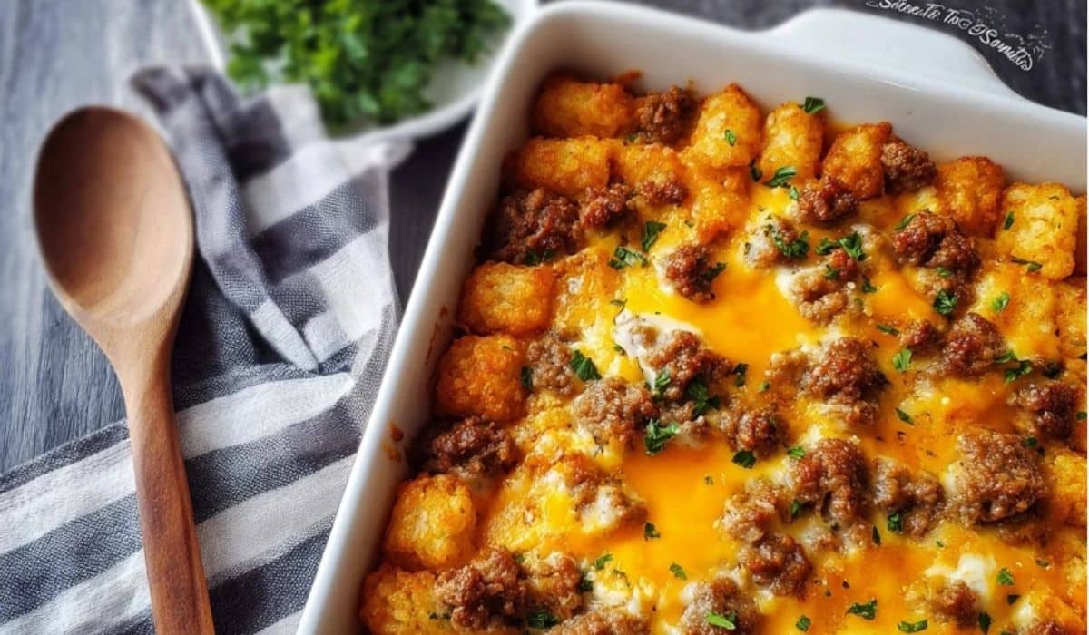 Sausage Egg and Cheese Tater Tot Casserole served in a white dish with melted cheddar and golden tots
