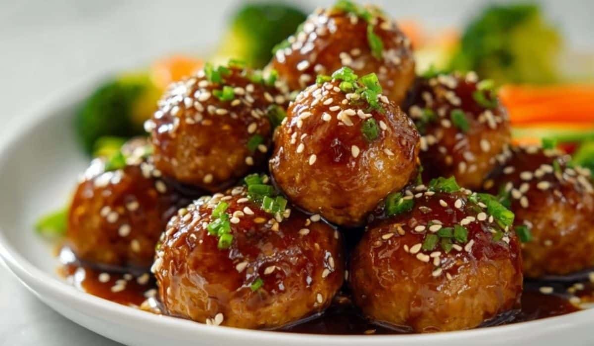 Teriyaki Chicken Meatballs served on a white plate with sesame seeds and vegetables