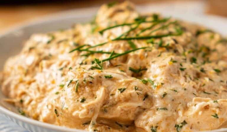 Slow Cooker Cream Cheese Chicken served creamy with herbs in a white bowl