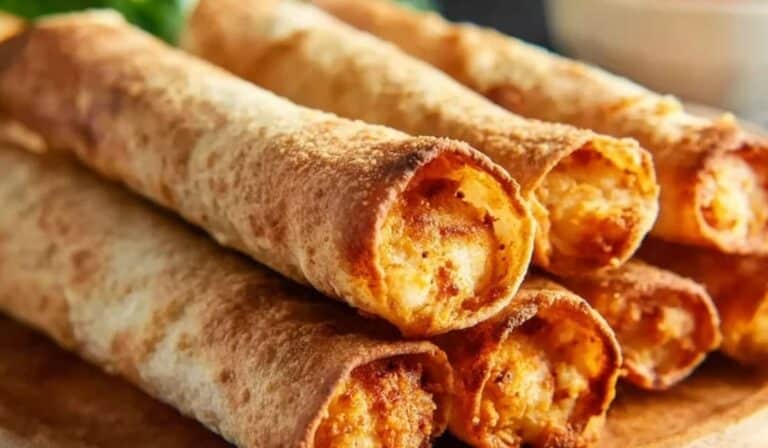 Golden Air Fryer Homemade Taquitos stacked on a wooden plate