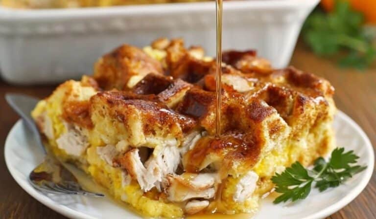 Chicken and Waffles Casserole topped with maple syrup served on a white plate. Caption: