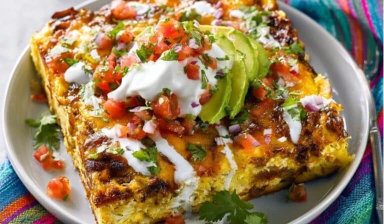 Mexican Breakfast Casserole topped with avocado, salsa, and sour cream