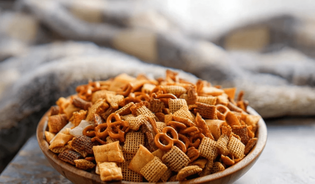 Best Chex Mix Recipe served in a wooden bowl with golden seasoning