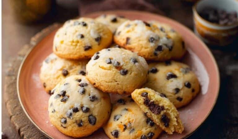 Orange Chocolate Chip Ricotta Cookies stacked on a white plate