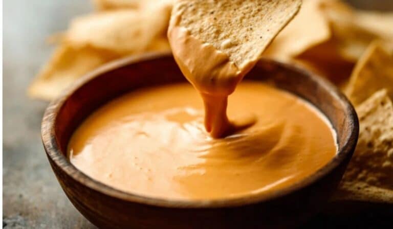 Spicy Nacho Cheese Sauce served with chips and jalapeños