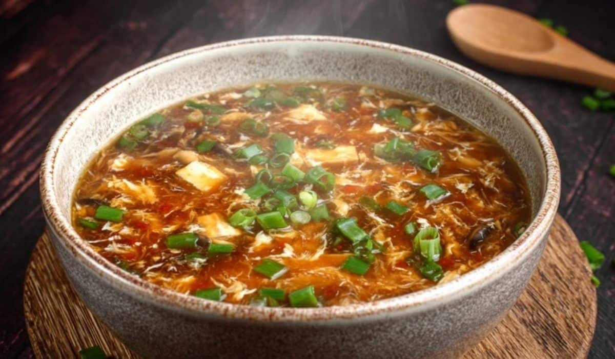 Chinese Hot and Sour Soup in black bowl with steam