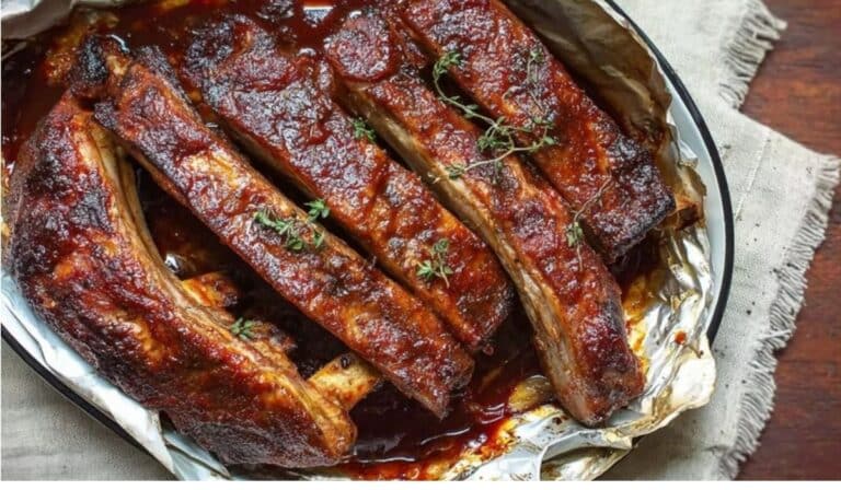 3-Step Fall off the Bone Ribs sliced on a platter with glossy BBQ sauce