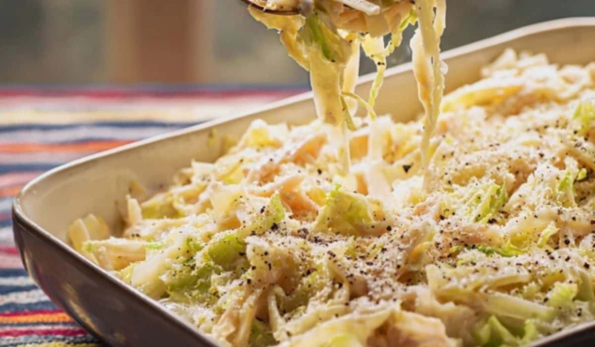 Creamy cabbage alfredo with parmesan in a skillet on a wooden table
