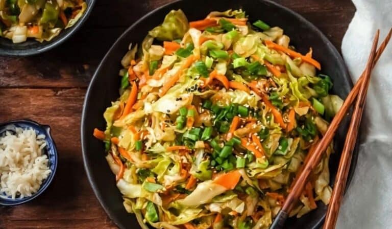 Quick cabbage stir fry in a wok with sesame seeds and green onions