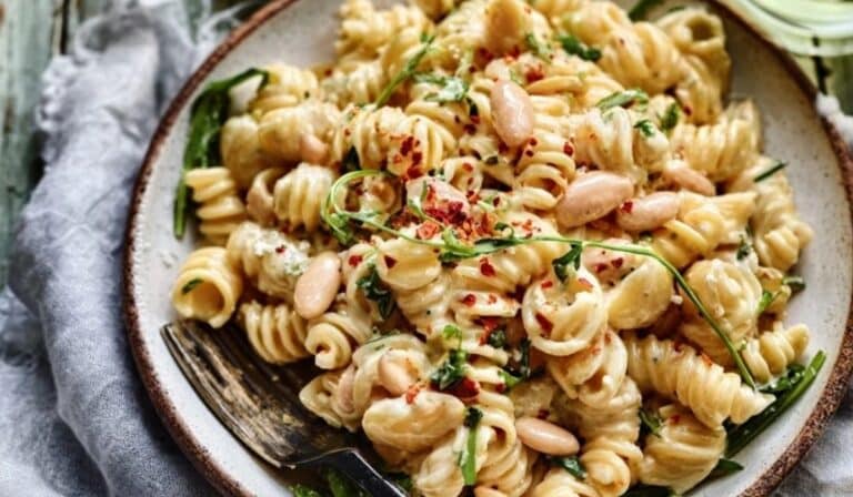 Creamy white bean pasta in a ceramic bowl with parsley and Parmesan